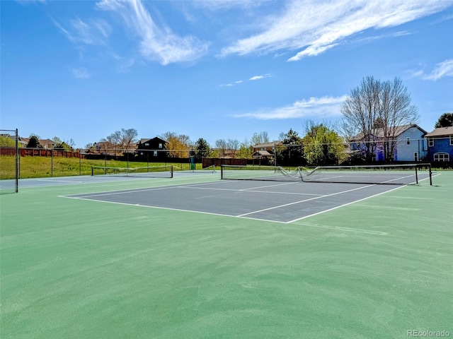 view of sport court with fence and a residential view