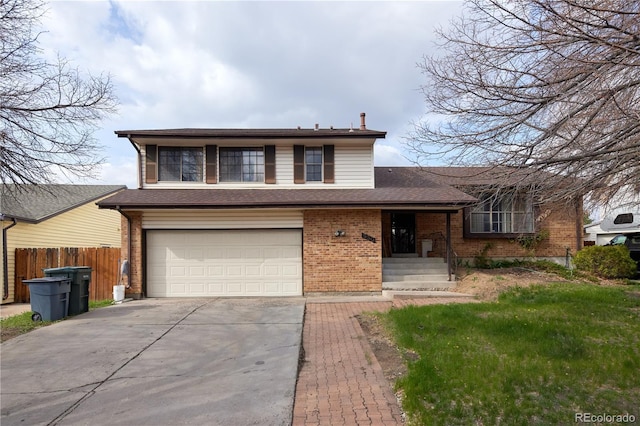 split level home with an attached garage, fence, brick siding, and concrete driveway
