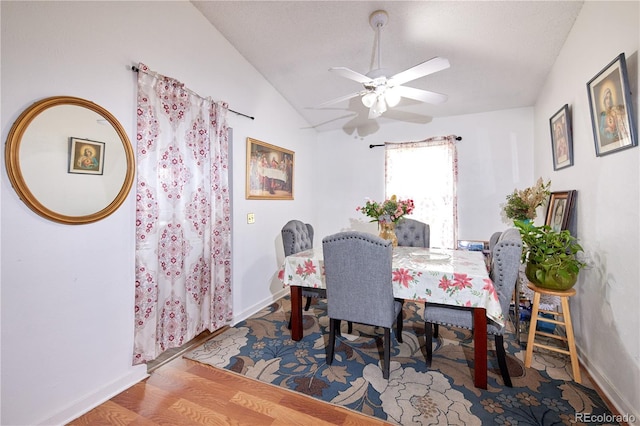 dining space with baseboards, a ceiling fan, lofted ceiling, and wood finished floors