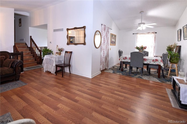 living area featuring ceiling fan, stairs, wood finished floors, lofted ceiling, and visible vents