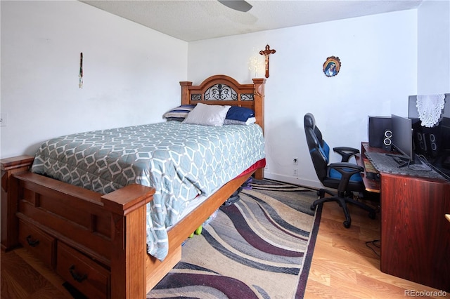 bedroom featuring a textured ceiling, a ceiling fan, and wood finished floors