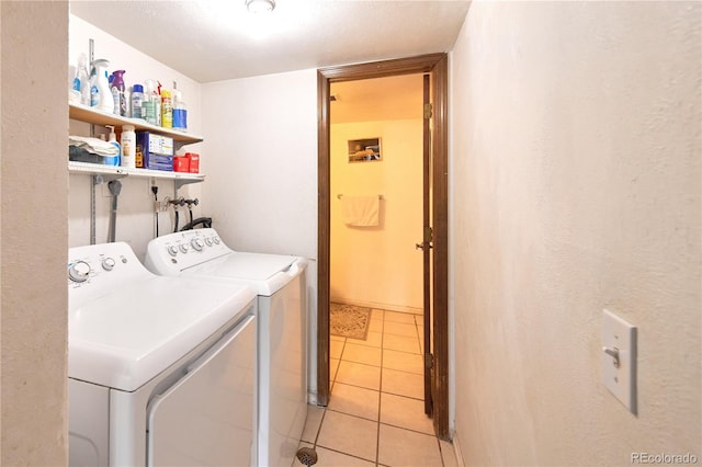 laundry room featuring light tile patterned floors, laundry area, and washing machine and dryer