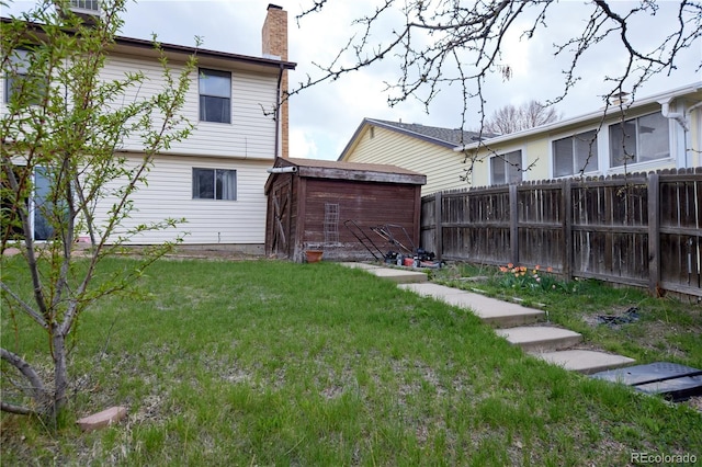 view of yard featuring an outdoor structure, fence, and a storage shed