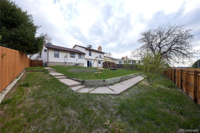 view of yard with a fenced backyard and a playground