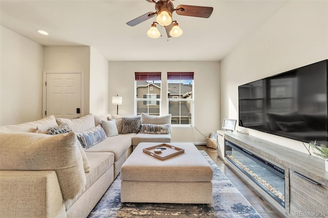 living room featuring ceiling fan and dark hardwood / wood-style floors