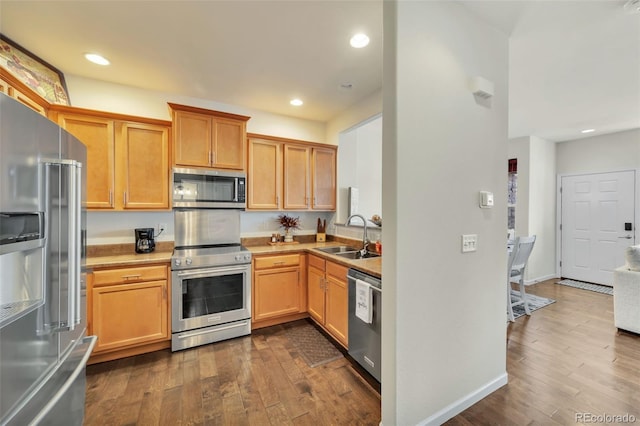 kitchen featuring appliances with stainless steel finishes, dark hardwood / wood-style floors, and sink