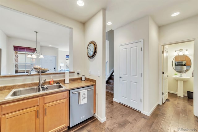 kitchen featuring pendant lighting, wood-type flooring, dishwasher, and sink