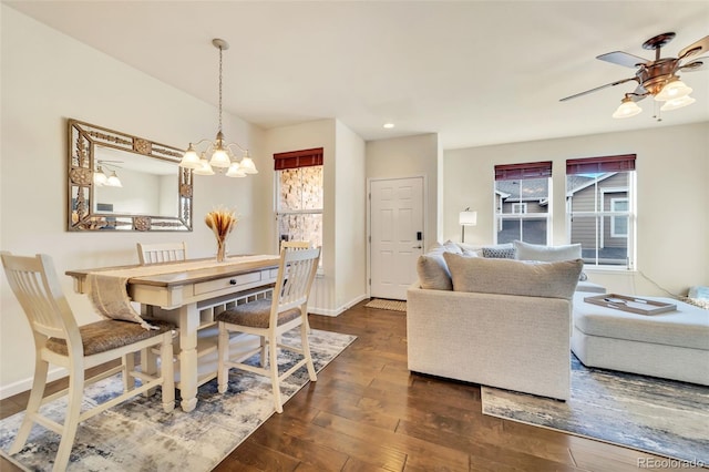 dining area featuring ceiling fan with notable chandelier and dark hardwood / wood-style floors