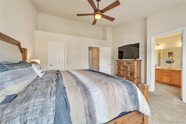 bedroom featuring ceiling fan, ensuite bathroom, and light carpet