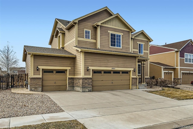 craftsman-style home featuring driveway, an attached garage, and fence