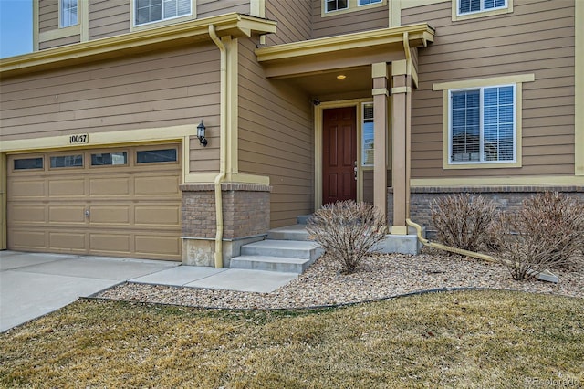 entrance to property with driveway and an attached garage