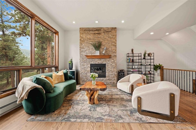 living room with a fireplace, baseboard heating, recessed lighting, and wood finished floors