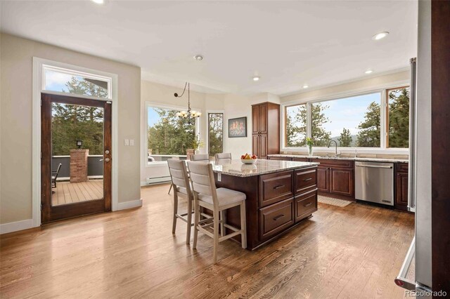 kitchen with baseboard heating, dishwasher, a chandelier, a center island, and a wealth of natural light