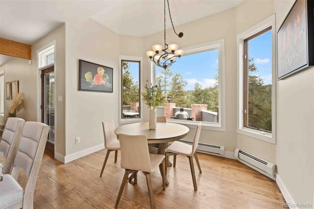 dining space with light wood-style floors, baseboards, a notable chandelier, and baseboard heating