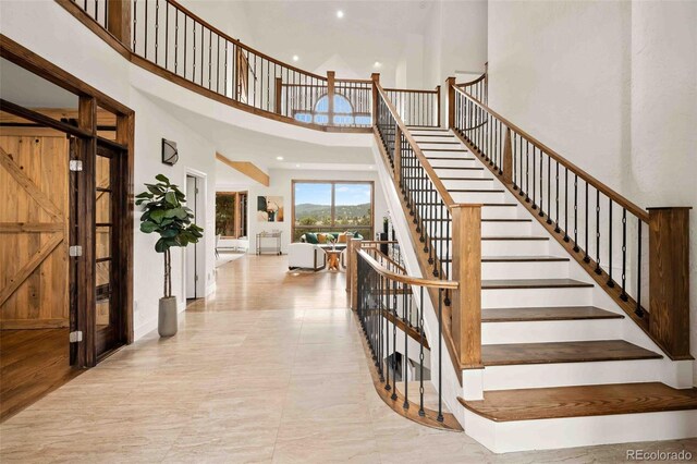 stairway featuring recessed lighting and a high ceiling