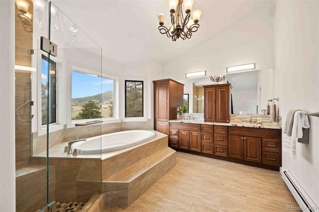 full bath with a garden tub, double vanity, baseboard heating, a sink, and a notable chandelier
