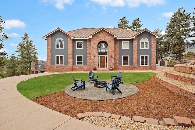 view of front of house with an outdoor structure, a front lawn, a fire pit, a storage unit, and a tile roof