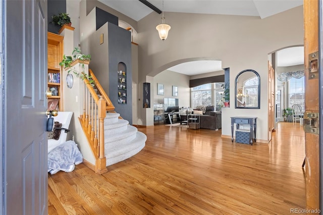 foyer featuring plenty of natural light, high vaulted ceiling, and light wood-type flooring