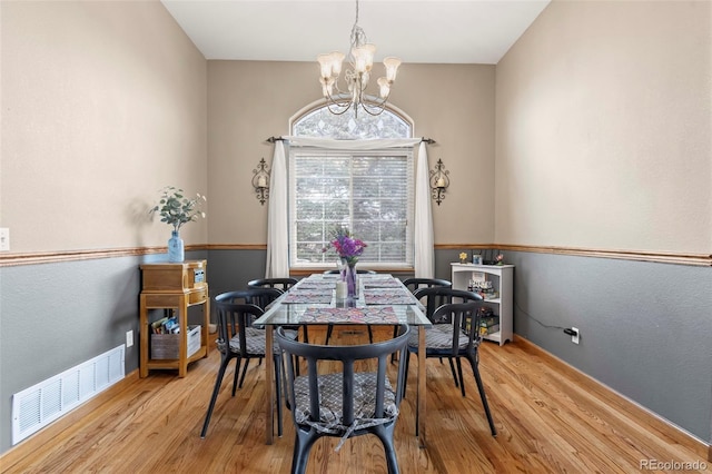 dining space featuring a notable chandelier and light hardwood / wood-style floors