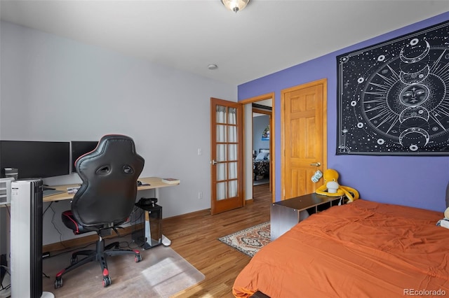 bedroom featuring french doors and light wood-type flooring