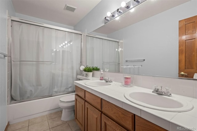 full bathroom featuring tile patterned flooring, bath / shower combo with glass door, vanity, and toilet