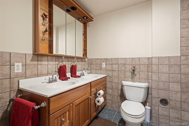 bathroom featuring tile patterned floors, vanity, toilet, and tile walls