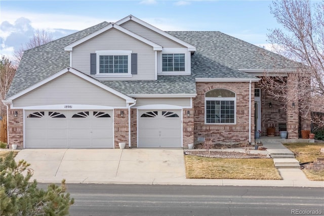 traditional home with concrete driveway, a shingled roof, and brick siding