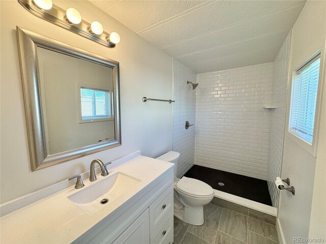 8480 Adams Way, Denver, CO 80229 - full bathroom featuring tiled shower, vanity, a textured ceiling, and marble finish flooring