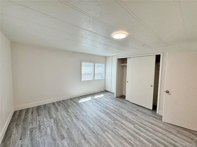 8480 Adams Way, Denver, CO 80229 - unfurnished bedroom with light wood-style flooring, a closet, and a textured ceiling