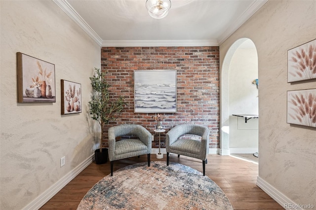 living area featuring arched walkways, crown molding, baseboards, and wood finished floors