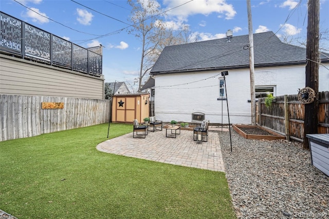 back of property featuring an outbuilding, a lawn, a patio area, and a fenced backyard