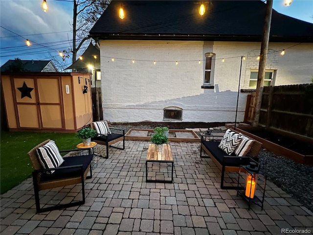 view of patio featuring an outbuilding, fence, and a storage shed