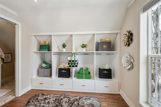 mudroom featuring vaulted ceiling, built in shelves, wood finished floors, and baseboards