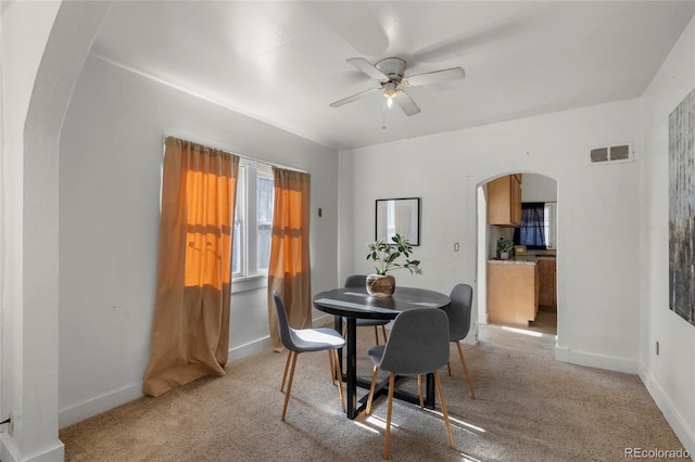 dining room featuring ceiling fan and light colored carpet