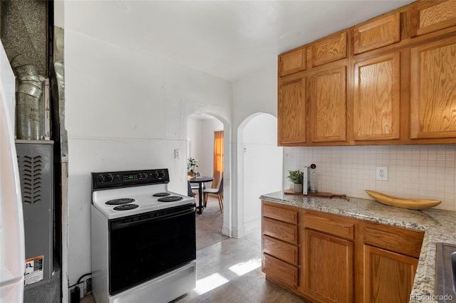 kitchen with white range with electric stovetop, light stone countertops, and decorative backsplash