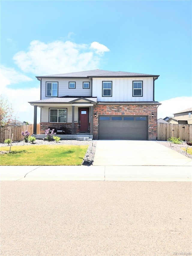 traditional home featuring concrete driveway, brick siding, a garage, and fence