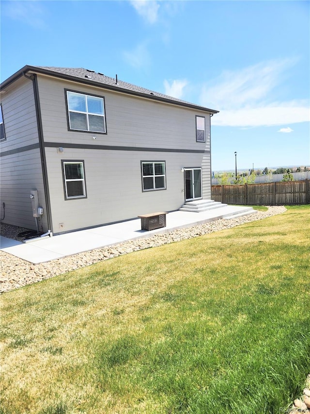 rear view of property with a yard, a patio, and fence