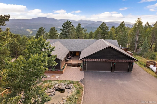 26452 Wolverine Trl, Evergreen, CO 80439 - view of front of house featuring a mountain view, an attached garage, and driveway