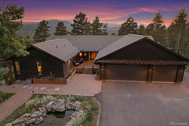 26452 Wolverine Trl, Evergreen, CO 80439 - view of front facade featuring driveway, a mountain view, and a garage