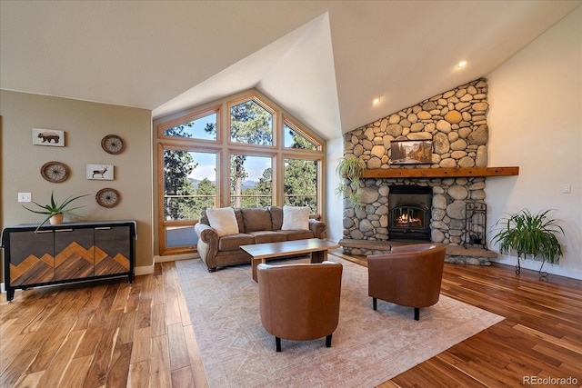 26452 Wolverine Trl, Evergreen, CO 80439 - living room featuring wood finished floors, a stone fireplace, baseboards, and high vaulted ceiling