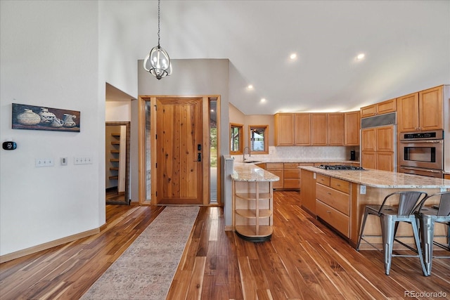 26452 Wolverine Trl, Evergreen, CO 80439 - kitchen featuring stainless steel appliances, a sink, wood finished floors, light stone counters, and recessed lighting