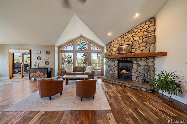 26452 Wolverine Trl, Evergreen, CO 80439 - living room with a stone fireplace, vaulted ceiling, wood finished floors, and baseboards