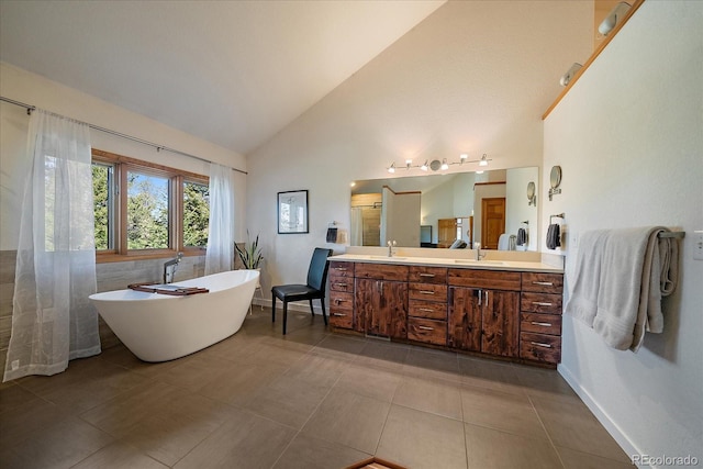 26452 Wolverine Trl, Evergreen, CO 80439 - bathroom featuring double vanity, a freestanding tub, tile patterned floors, high vaulted ceiling, and baseboards