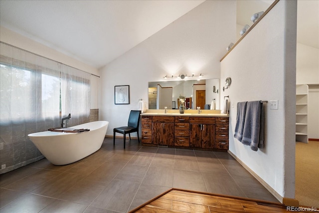 26452 Wolverine Trl, Evergreen, CO 80439 - full bath with double vanity, a freestanding bath, tile patterned flooring, high vaulted ceiling, and baseboards