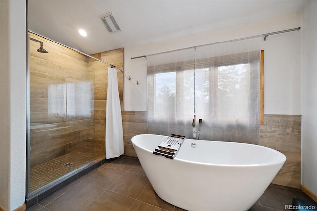 26452 Wolverine Trl, Evergreen, CO 80439 - bathroom featuring tile walls, tile patterned flooring, a tile shower, and a freestanding tub