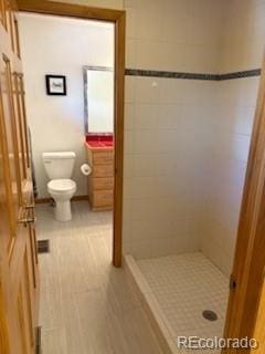 26452 Wolverine Trl, Evergreen, CO 80439 - full bathroom with toilet, tiled shower, and tile patterned floors