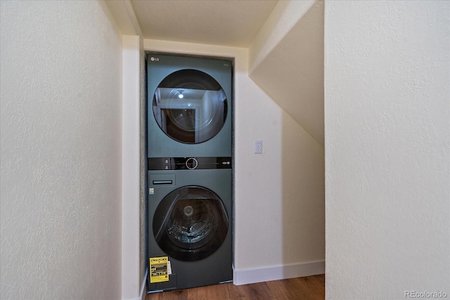 26452 Wolverine Trl, Evergreen, CO 80439 - laundry area with estacked washer and dryer, baseboards, and wood finished floors