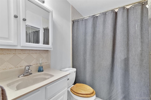 bathroom with vanity, decorative backsplash, and toilet