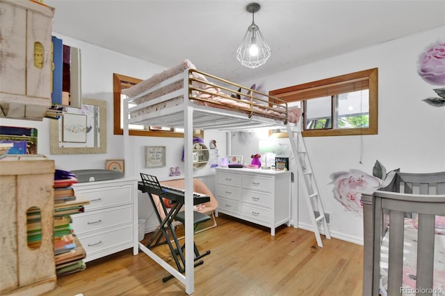 bedroom with light hardwood / wood-style floors and a nursery area