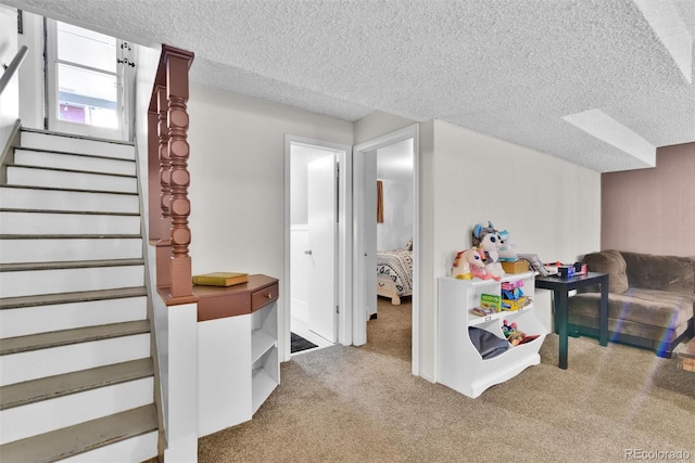 playroom with a textured ceiling and light colored carpet